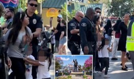 迪斯尼乐园的妈妈被带着手铐拖出来，旁边是歇斯底里的孩子，她试图不付钱就溜进公园